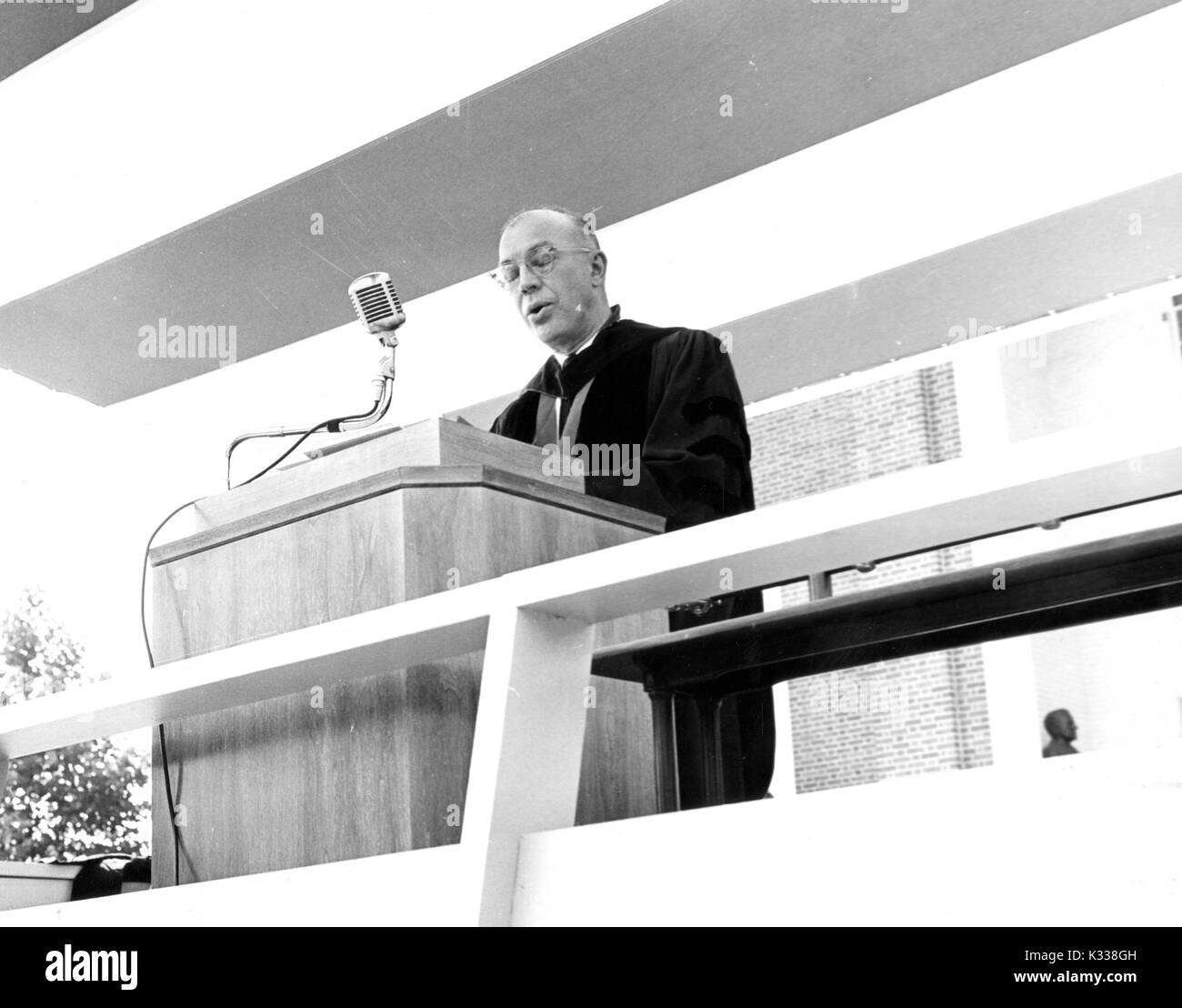 À l'ouverture de la cérémonie, le président de l'Université Johns Hopkins, Milton Stover Eisenhower s'élève à un podium sur scène en portant une robe universitaire, en donnant un discours avec ses yeux pour coffrage fermé, autour de 55 ans, Baltimore, Maryland, juin, 1959. Banque D'Images