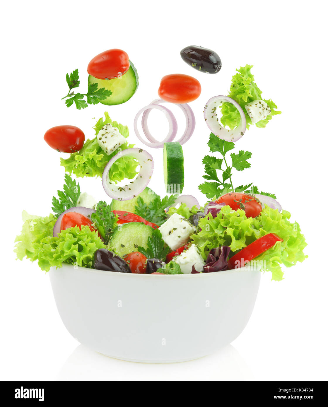 Mélange de légumes frais tomber dans un bol de salade Banque D'Images