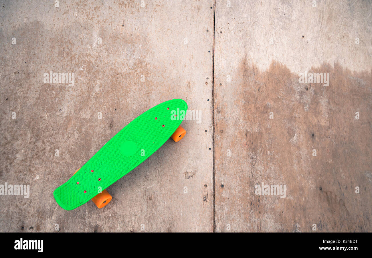 Penny vert unique sur un half-pipe en bois. Banque D'Images