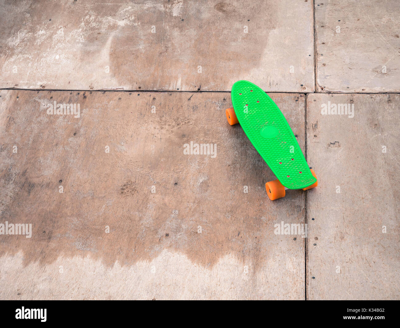Penny vert unique sur un half-pipe en bois. Banque D'Images