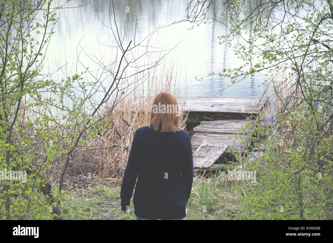 Femme à l'ancienne jetée du lac en un jour de printemps l'horizontale Banque D'Images