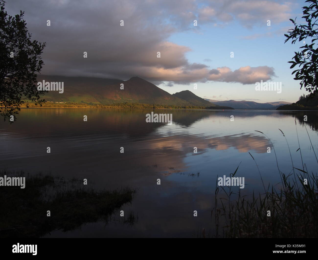 Lakeland Fells et nuages éclairées par soir ligh et feflected dans le lac Bassenthwaite, Cumbria, Royaume-Uni Banque D'Images