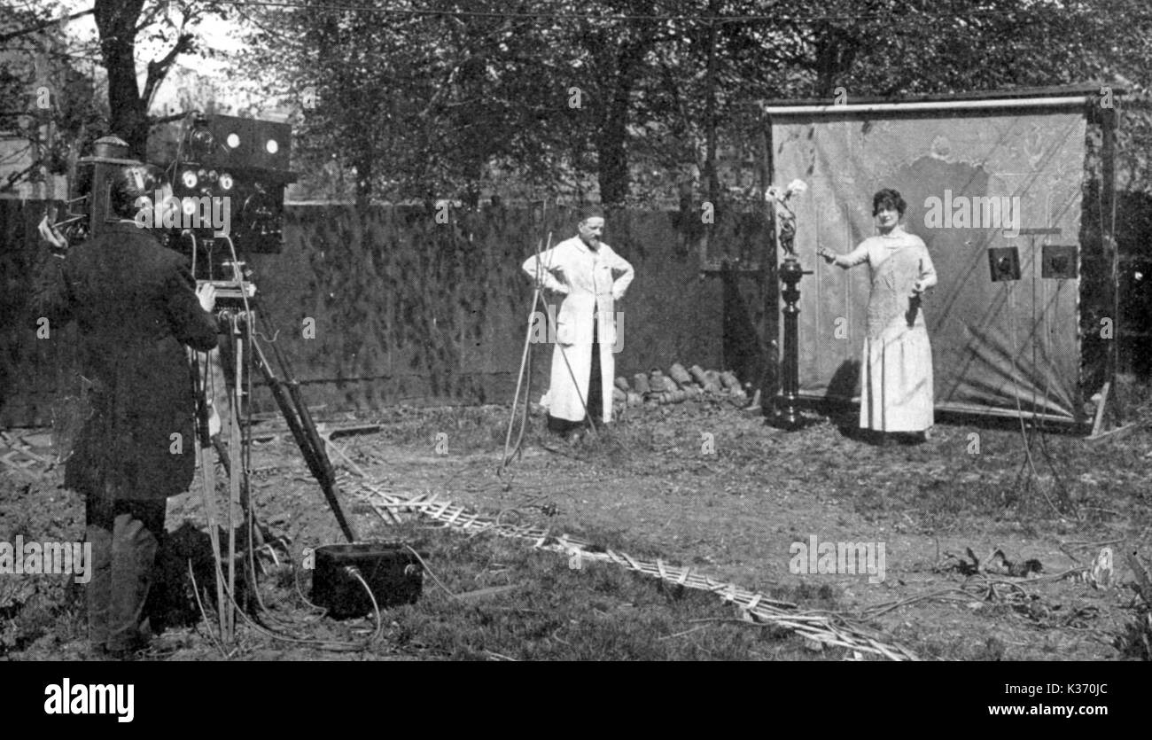 EUGENE LAUSTE FILMANT AVEC SON SON SUR CAMÉRA DANS SON JARDIN À BRIXTON, LONDRES EUGENE LAUSTE (MANTEAU BLANC) FILMANT AVEC SON SON SUR CAMÉRA DANS SON JARDIN À BRIXTON, LONDRES Banque D'Images