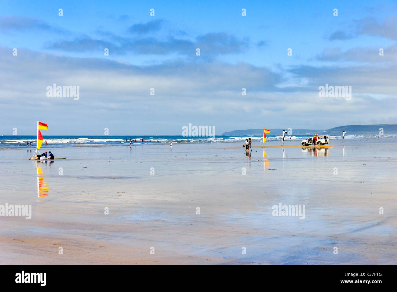 Drapeaux d'avertissement rouges et jaunes, les surfers et sauveteur RNLI véhicule sur la plage de sable à marée basse, Westward Ho !, Devon, England, UK Banque D'Images