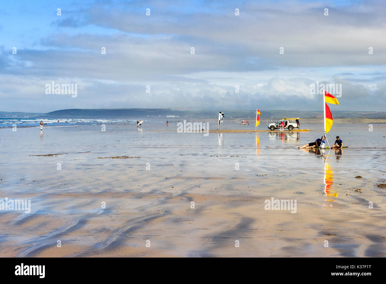 Drapeaux d'avertissement rouges et jaunes, les surfers et sauveteur RNLI véhicule sur la plage de sable à marée basse, Westward Ho !, Devon, England, UK Banque D'Images