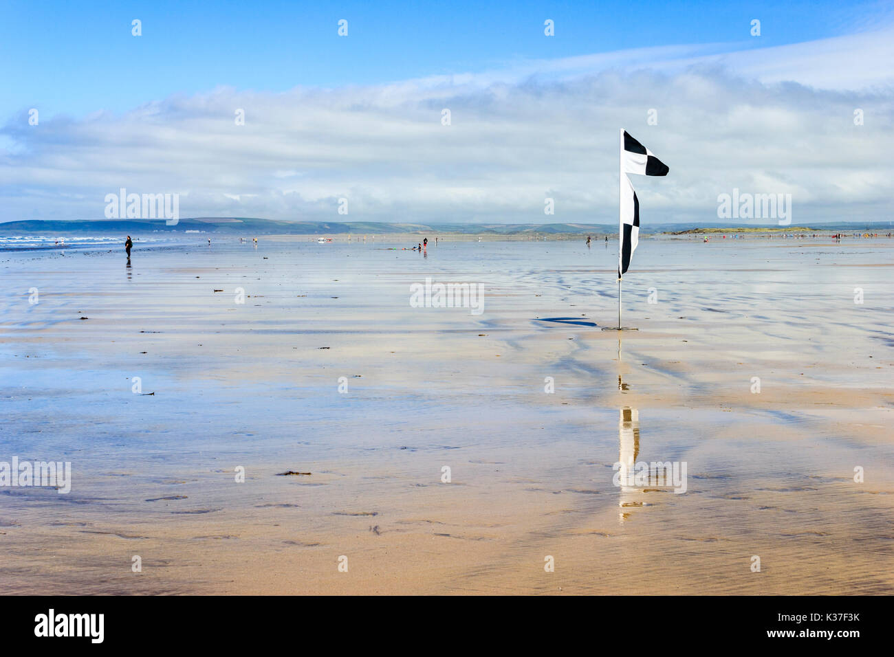 Avertissement en damier noir et blanc drapeau sur la plage de sable à marée basse, Westward Ho !, Devon, England, UK Banque D'Images