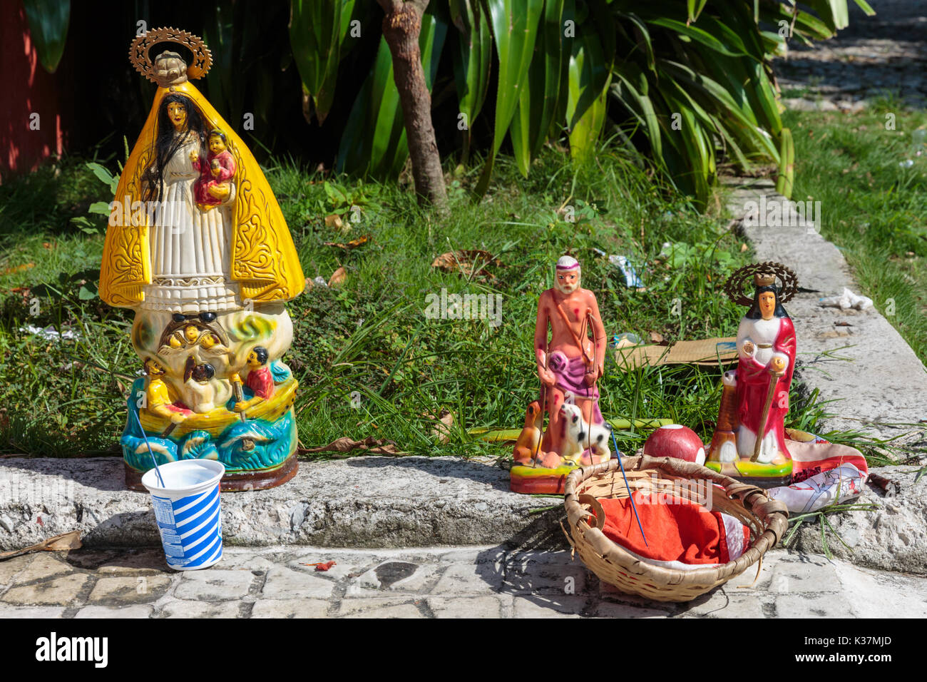 Santeria dolls et offrandes religieuses et les icônes des saints en face d'une église foi Santeria à Cuba, Regla Banque D'Images