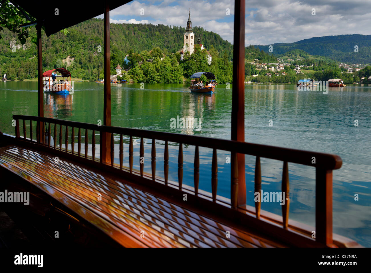 Voir l'île de bled d'église de pèlerinage de l'assomption de Marie et le bois d'aviron rameurs bateau Pletna les touristes sur le lac de Bled en Slovénie Banque D'Images