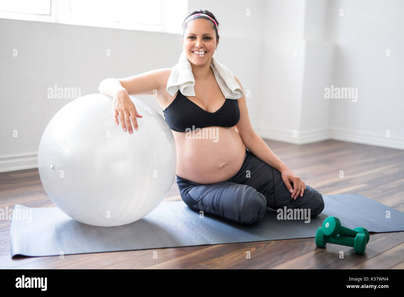 Femme enceinte avec haltères d'entraînement pour rester actif Banque D'Images