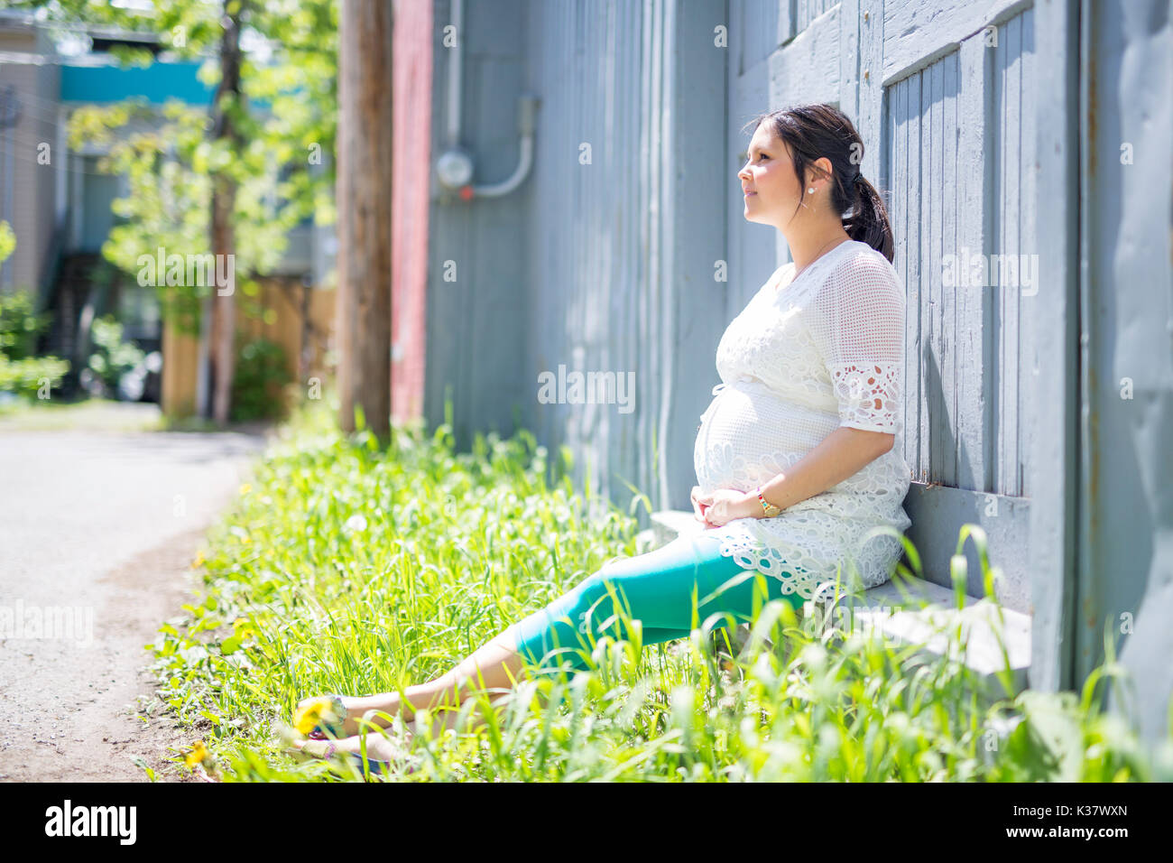 Femme enceinte posant dans le quartier Banque D'Images