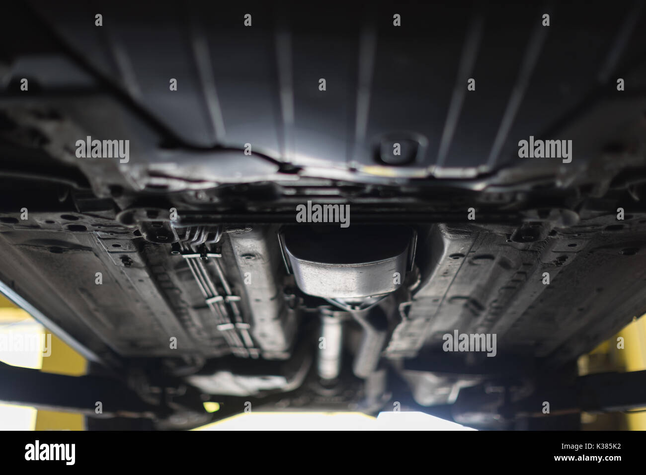 Affichage automatique du fond. Mécanicien Garage a soulevé la voiture sur l'ascenseur. Banque D'Images Affichage automatique du fond. Mécanicien Garage a soulevé la voiture sur l'ascenseur. Banque D'Images