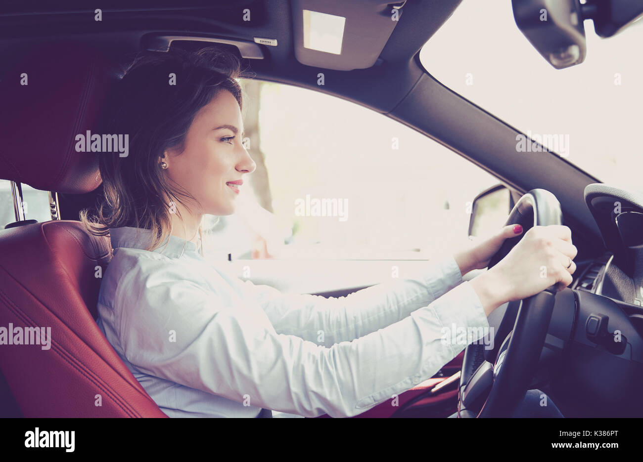 Portrait of a smiling young woman driving a car Banque D'Images
