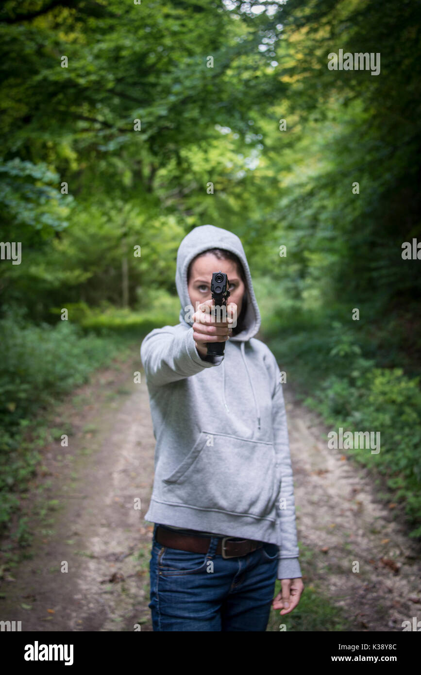 Femme braquer une arme portant un hoodie Banque D'Images