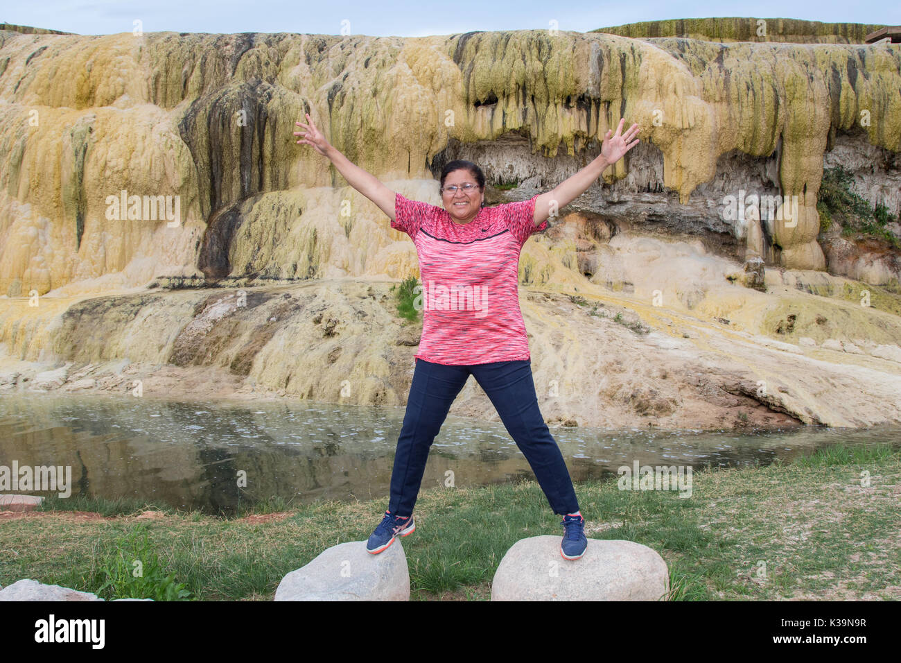 Asian woman posing avec ses bras en l'air par un gethermal exposée à Hot Springs State Park Thermopolis, WY, Banque D'Images