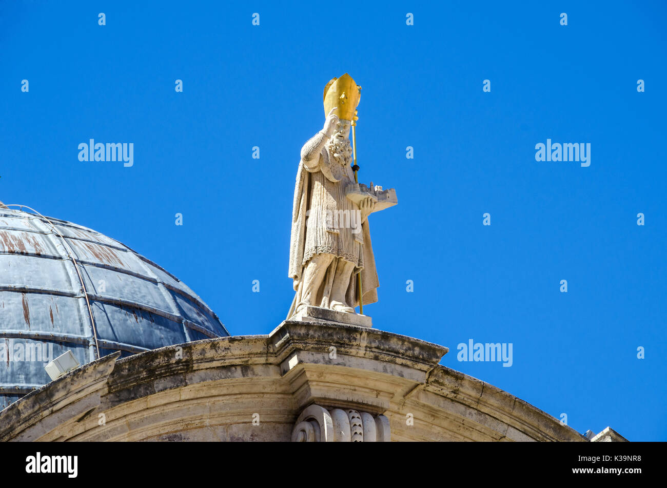 Statue de Saint Blaise en haut de la façade de l'église baroque de Saint Blaise dans la vieille ville de Dubrovnik. Le saint montre dans sa main gauche une échelle Banque D'Images