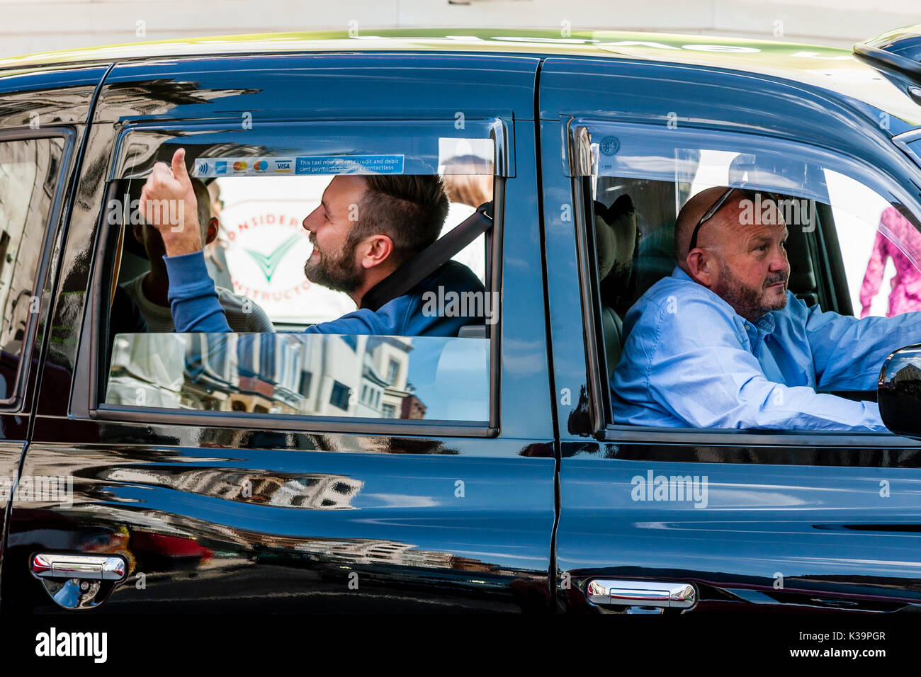 Un homme donne le coup de signer par la fenêtre d'un LondonTaxi, Old Bond Street, Londres, UK Banque D'Images