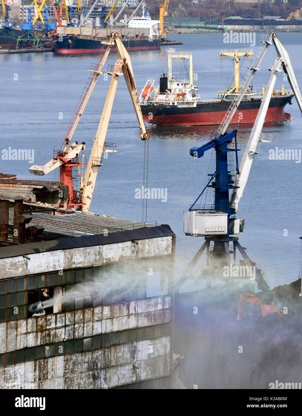 Le canon à eau dans le port arrosé l'entrepôt avec le charbon pour l'absence de poussière Banque D'Images