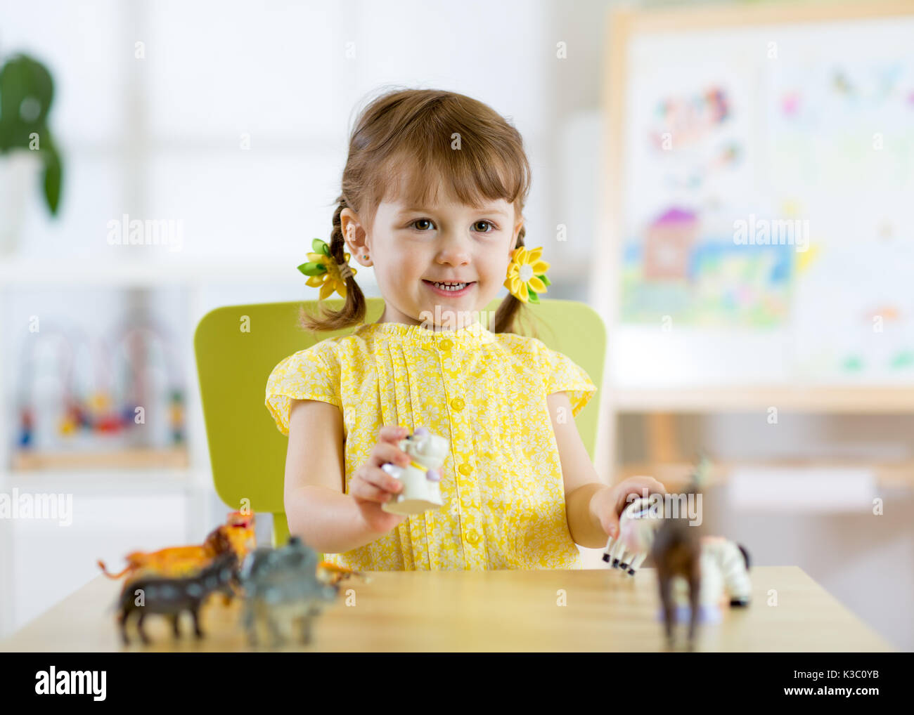 Heureux petit enfant fille. Tout-petit enfant souriant joue à la maison, animaux ou de pépinière d'âge préscolaire Banque D'Images