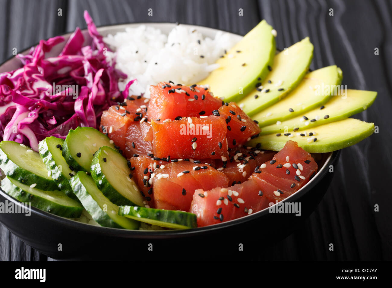 Thon ahi poke biologiques crus avec du riz et légumes bol close-up sur la table horizontale. Banque D'Images