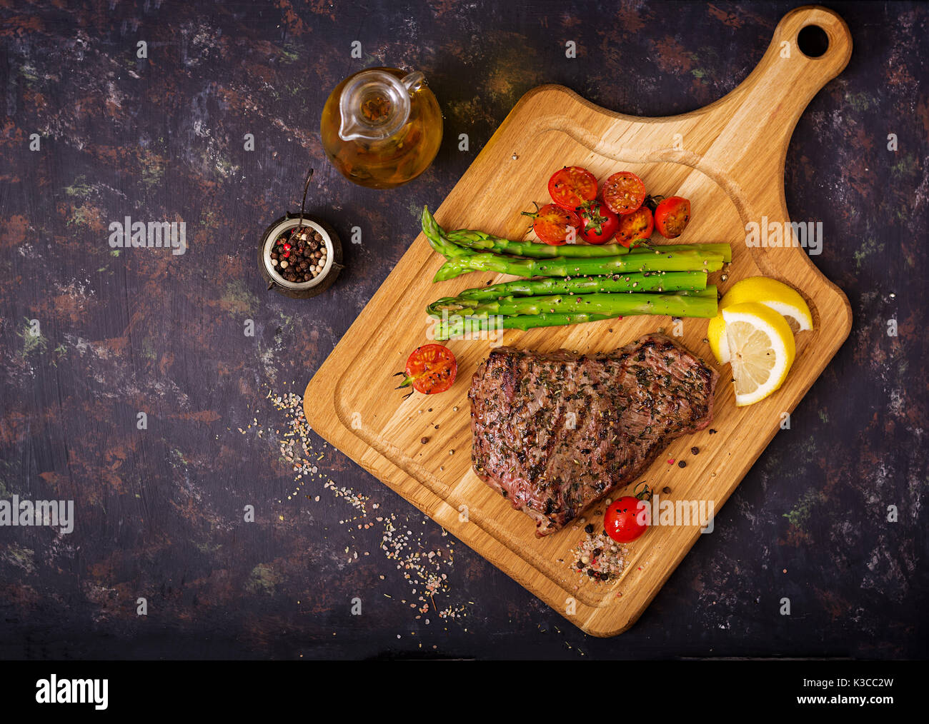 Steak de bœuf juteux rares avec des épices sur une planche en bois et garnir de l'asperge. Télévision. Vue de dessus Banque D'Images