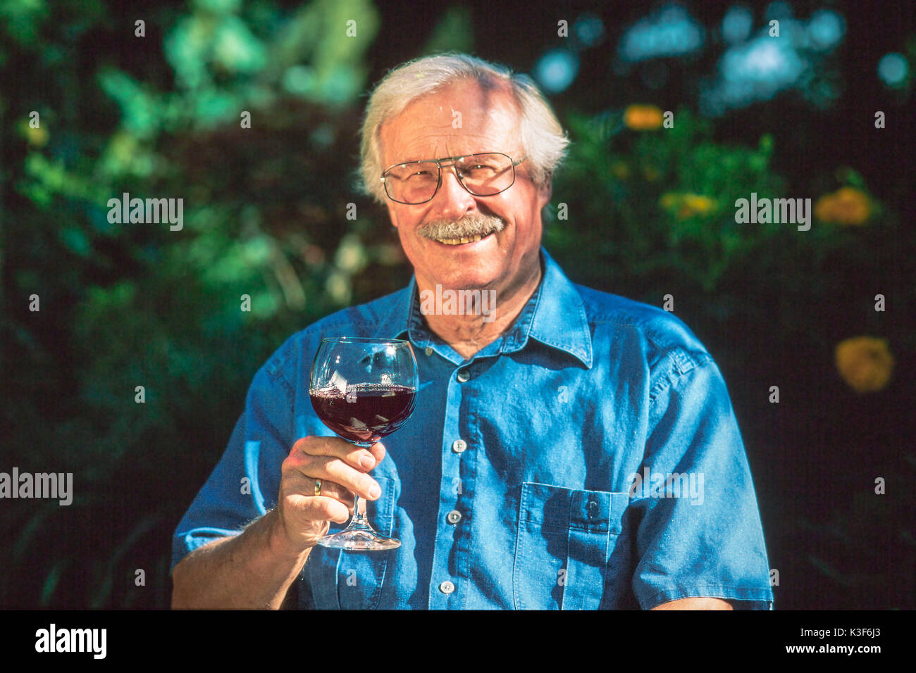 Vieil homme avec le verre de vin rouge Banque D'Images