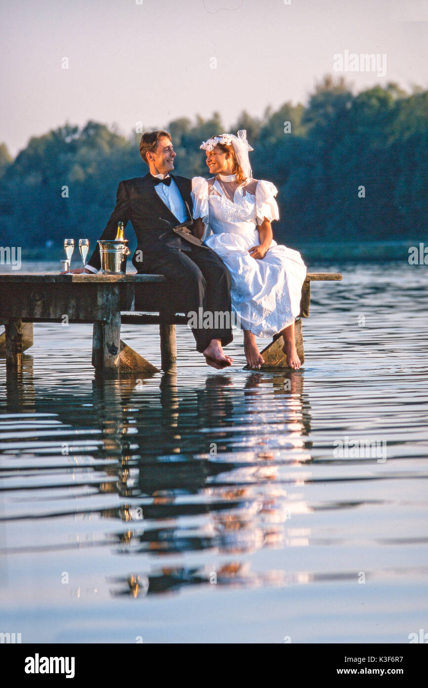 Wedding couple est assis sur un pont Banque D'Images