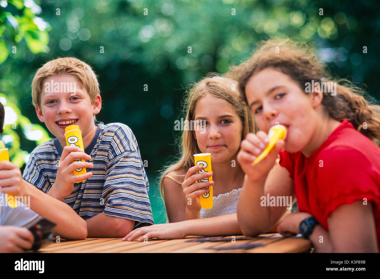 Groupe d'enfants / adolescents alors que manger des glaces Banque D'Images