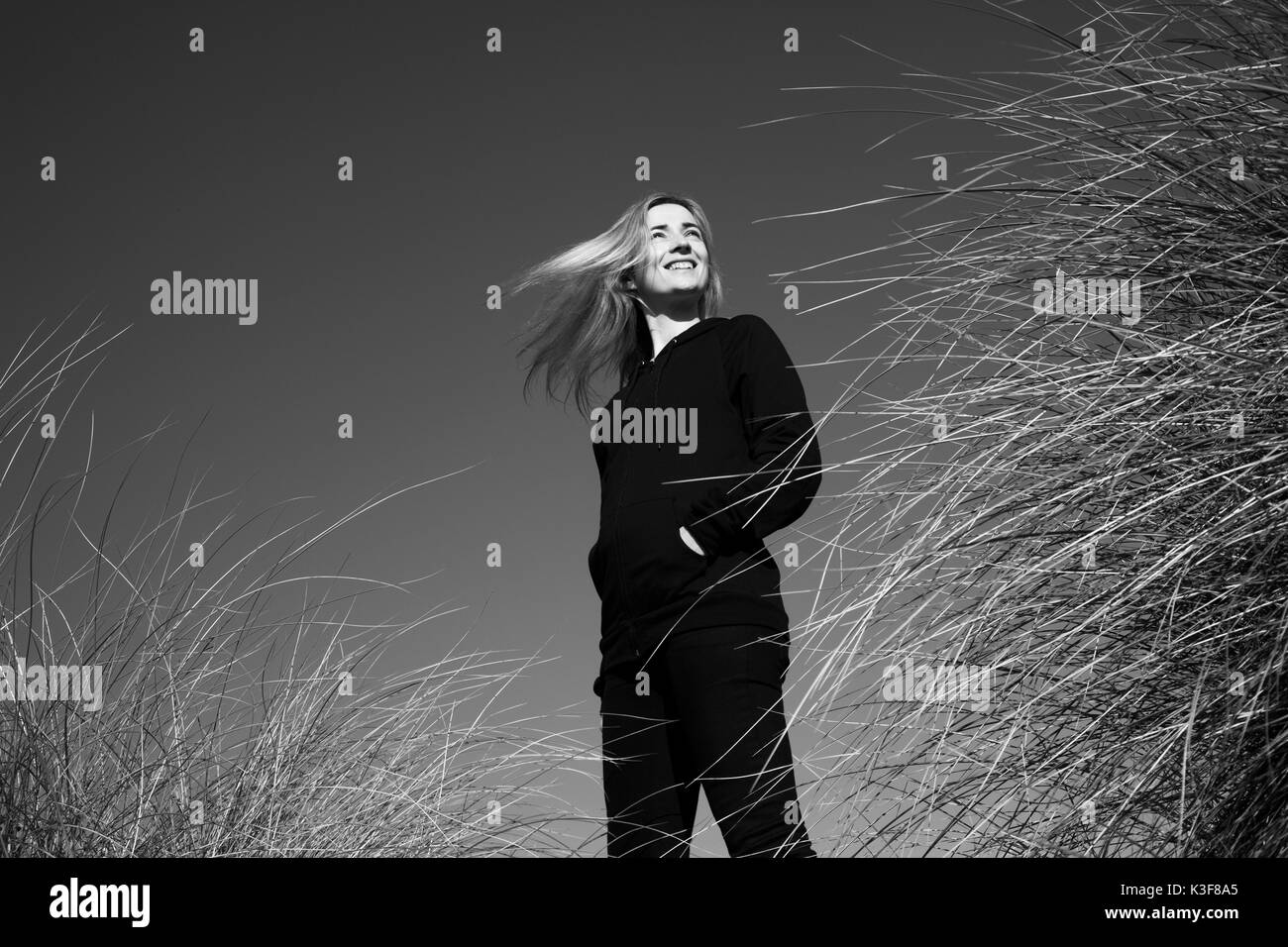 Portrait de femme souriante debout dans les herbes hautes Banque D'Images