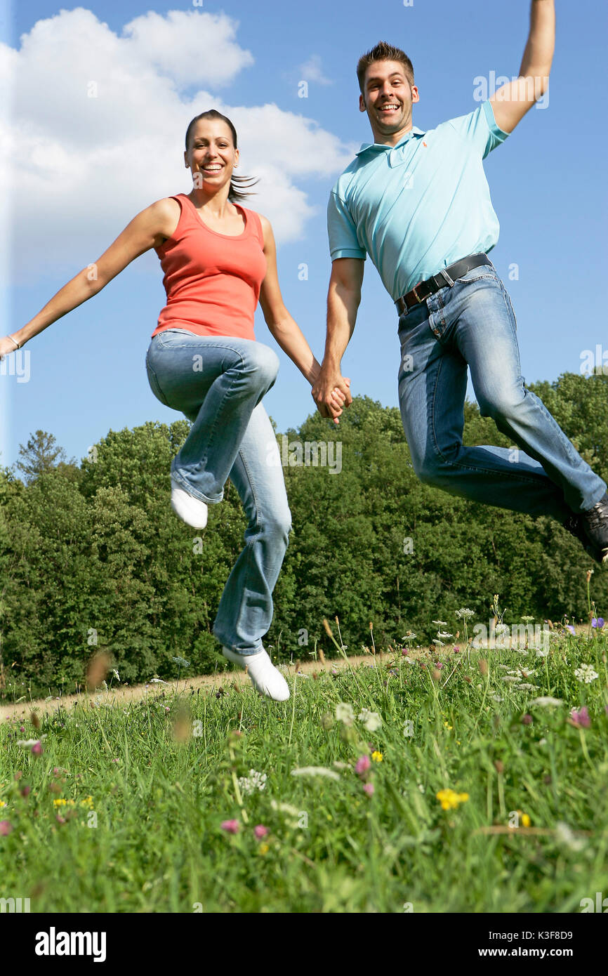 Jeune couple saute en l'air Banque D'Images