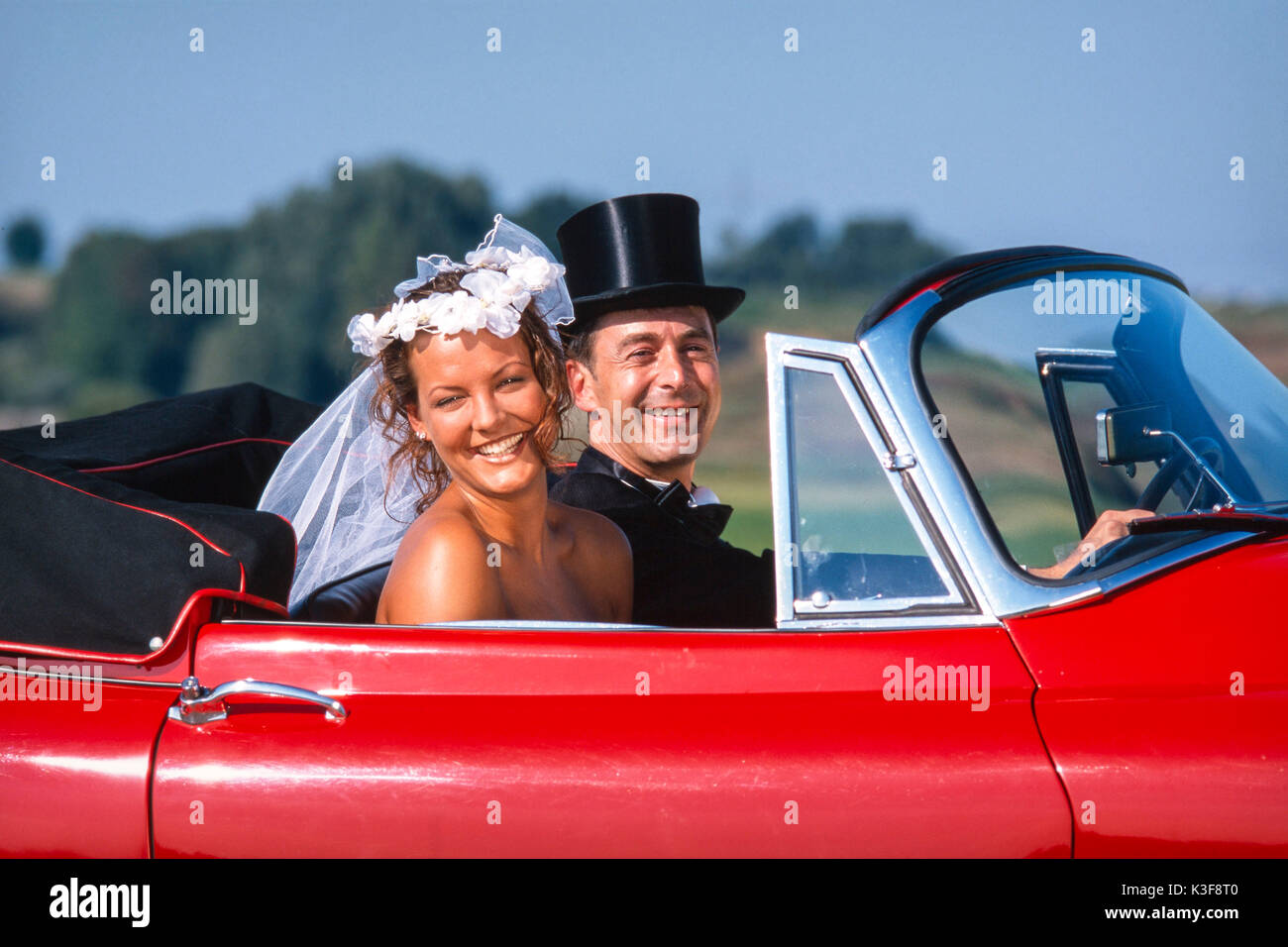 Wedding couple red cabriolet Banque D'Images Wedding couple red cabriolet Banque D'Images