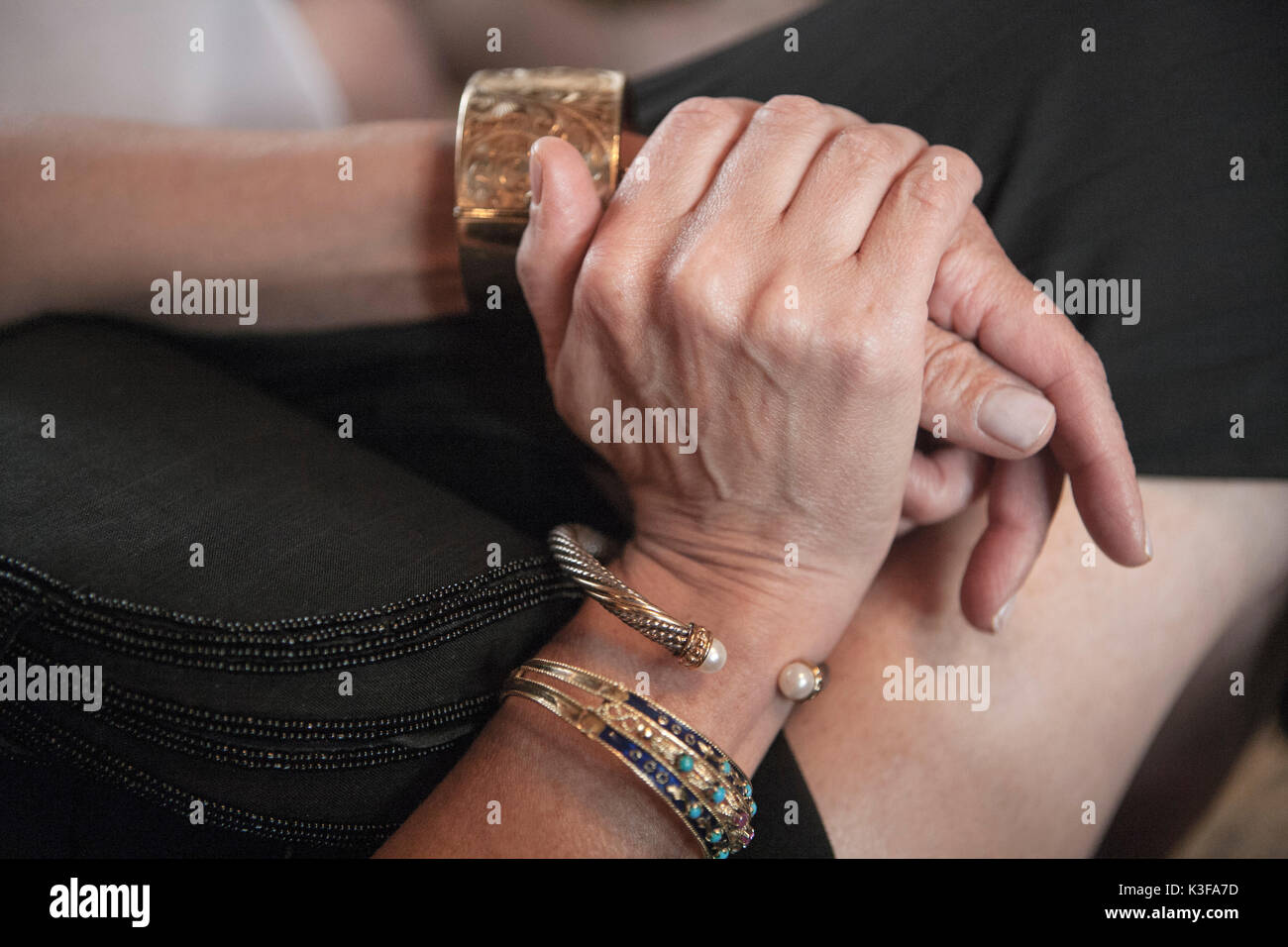 Femme assise avec des bracelets Banque D'Images