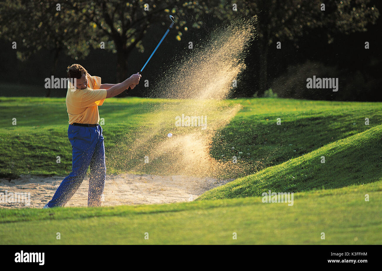 Homme hits balle de golf le bunker de sable golf club de Burgwalden Banque D'Images