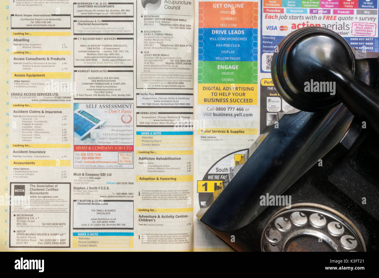 Un vieux téléphone sur une copie de Pages jaunes qui sont à arrêter la publication sous forme imprimée en 2018 Banque D'Images