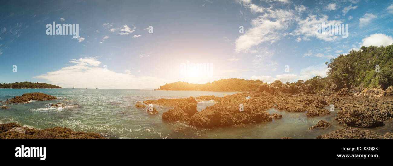 Panorama d'une plage de sable avec des pierres volcaniques et la mer turquoise en Nouvelle Zélande Banque D'Images