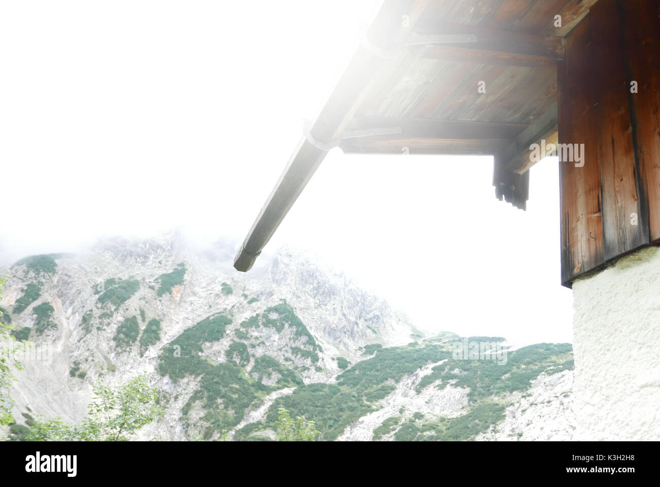 Mountain hut, hut toiture, gouttière en contre-jour et brouillard élevé Banque D'Images