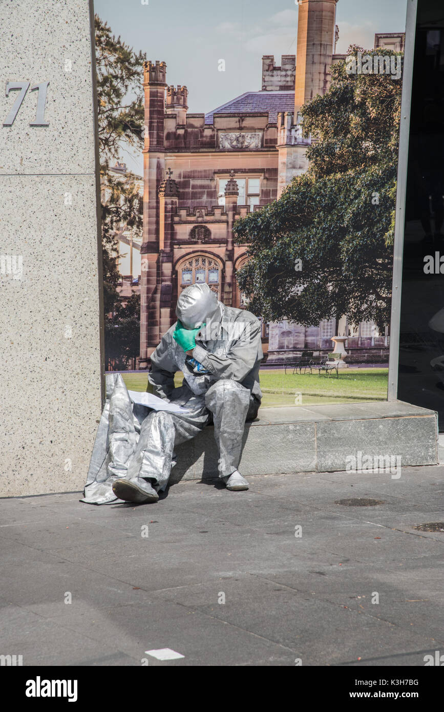 SYDNEY, NSW, Australie-novembre 20,2016 : argent rue costumés lecture busker dans la solitude au Circular Quay à Sydney, Australie Banque D'Images