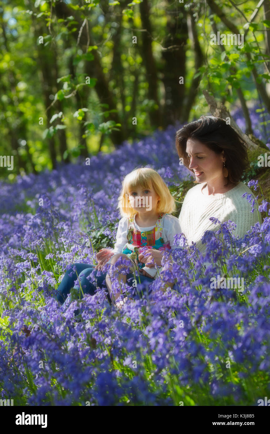 Une jeune mère avec son enfant dans un bois bluebell dans le Devon, Angleterre Royaume-uni Banque D'Images