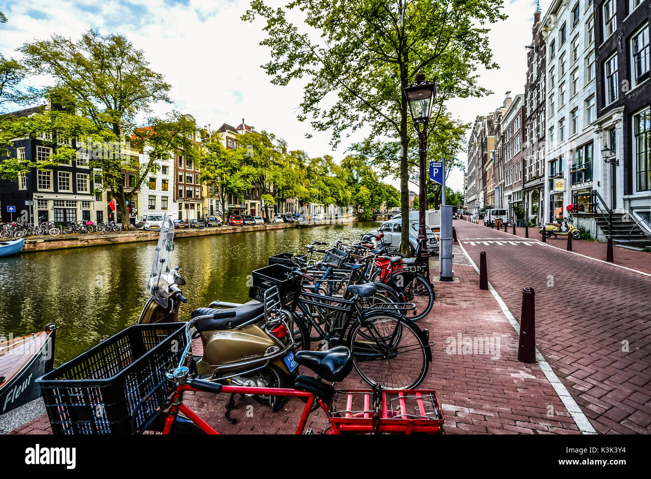Une ligne typique des bicyclettes et scooters en stationnement sur l'image au début de l'automne à Amsterdam Banque D'Images