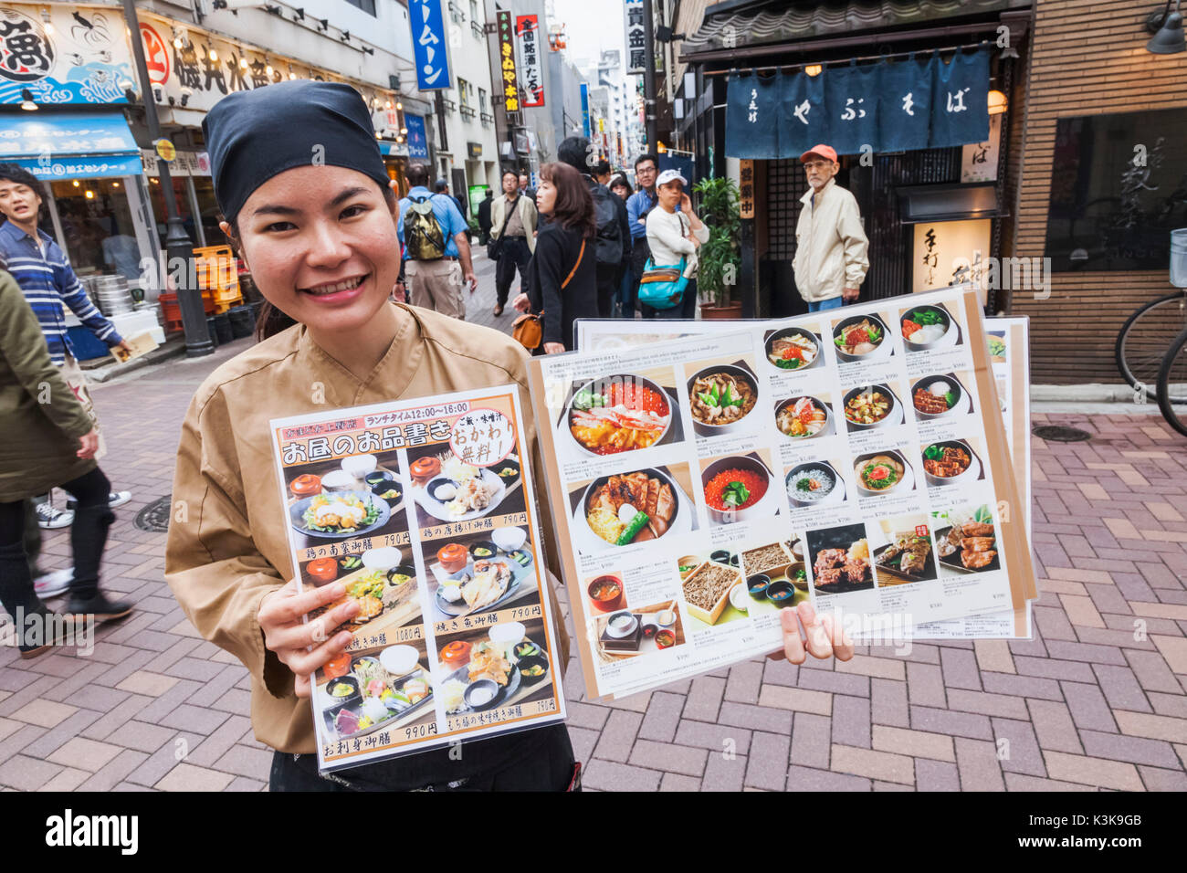 Japon, Tokyo, Ueno, Hoshu Ameyoko, rue Commerçante, Girl Holding Restaurant Menu Banque D'Images