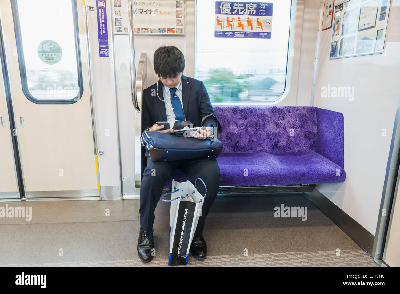 Japon, Tokyo, Hoshu, Train passager avec un ordinateur et l'iPhone Banque D'Images