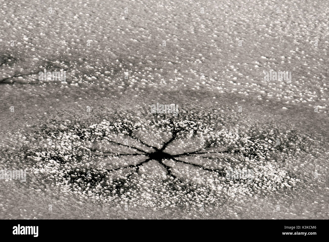 Plaque de glace avec un trou stellaire et les chutes de neige fraîche couvre Banque D'Images