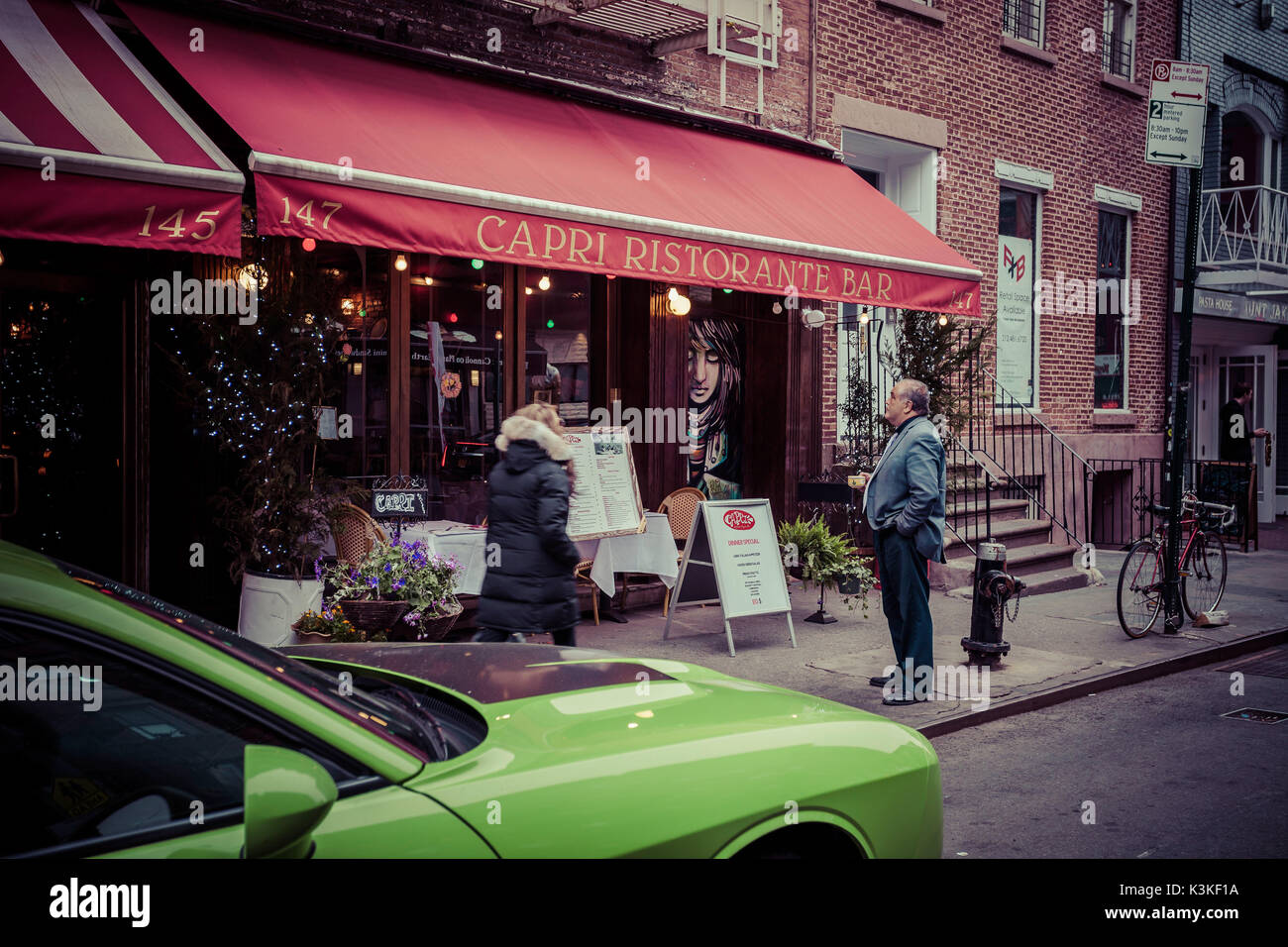 L'homme italien et une Chevrolet Camaro verte, en face d'une pizzeria, Little Italy, Manhattan, New York, USA Banque D'Images