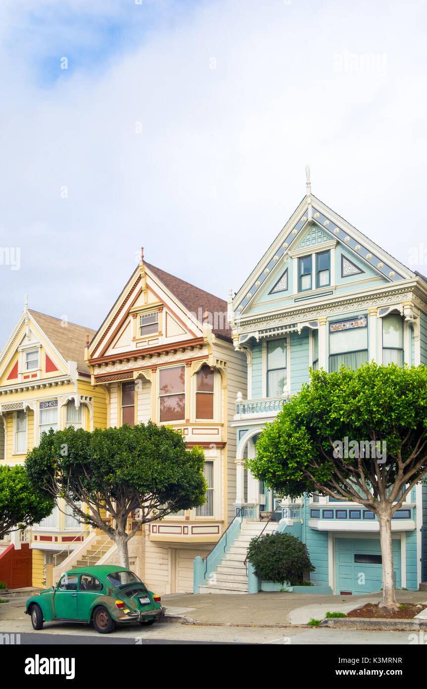 Un livre vert Volkswagen garée en face de la 'Painted Ladies' rangée de maisons victoriennes sur Steiner Street (à Alamo Square) à San Francisco. Banque D'Images