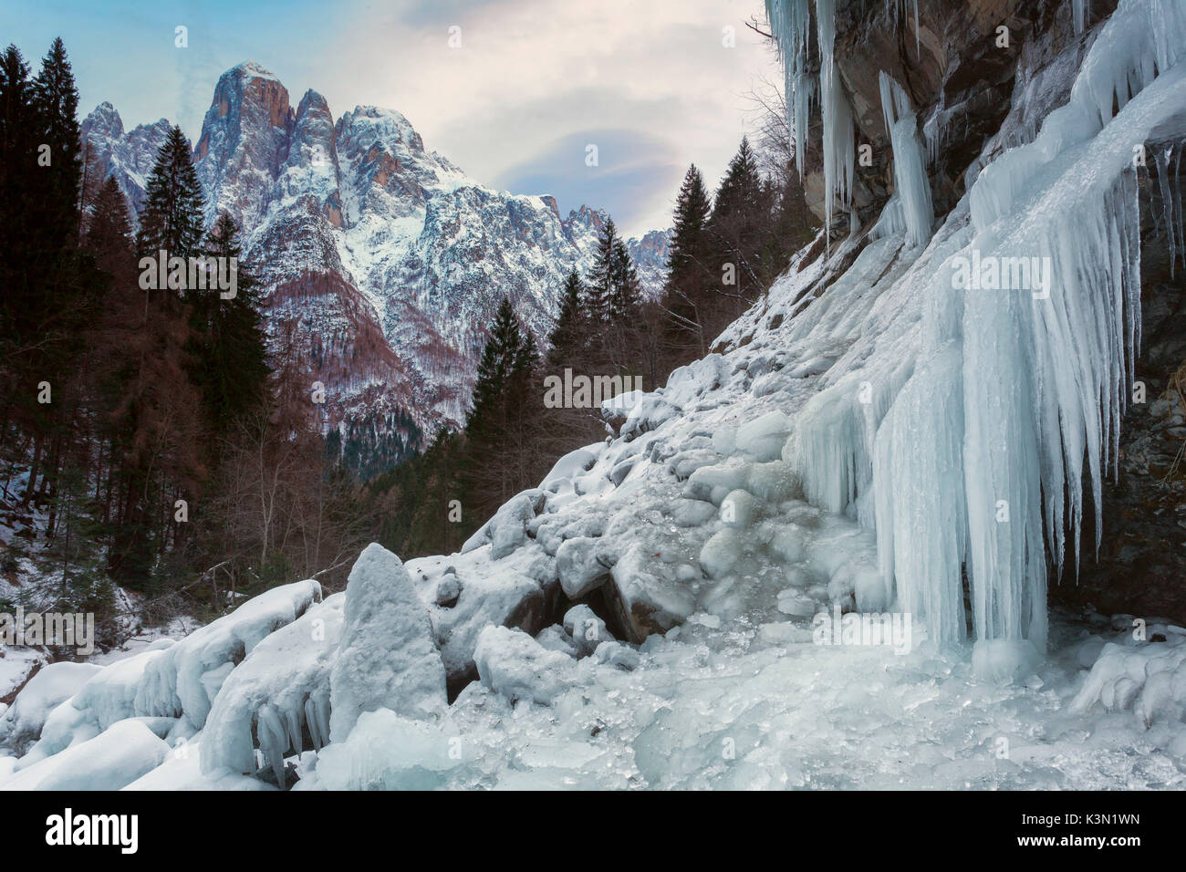 Les stalagmites de glace à l'Inferno cascade, dans l'arrière-plan l'Agner. La Cascata dell'Inferno (l'enfer cascade), clôturé par les structures de Agner cyclopéen, Pale di San Lucano et les balcons de pâle (Pale di San Martino) au fond de la vallée de San Lucano. En hiver, la glace est le roi, créant un décor digne du grand nord. Dolomites Banque D'Images