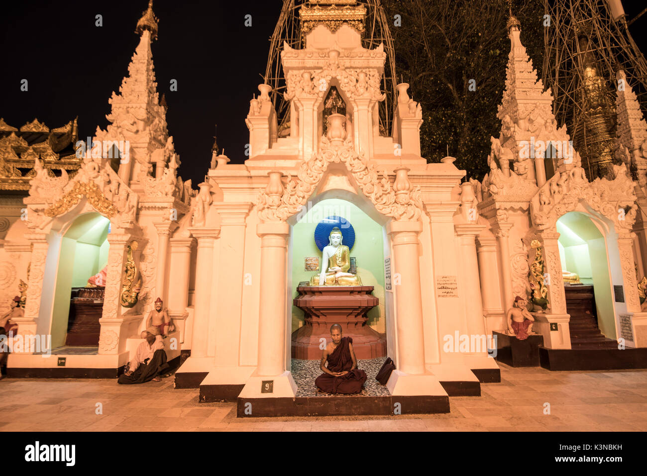 Yangon, Myanmar (Birmanie). Un moine en prière dans un petit stupa de la pagode Shwedagon la nuit. Banque D'Images
