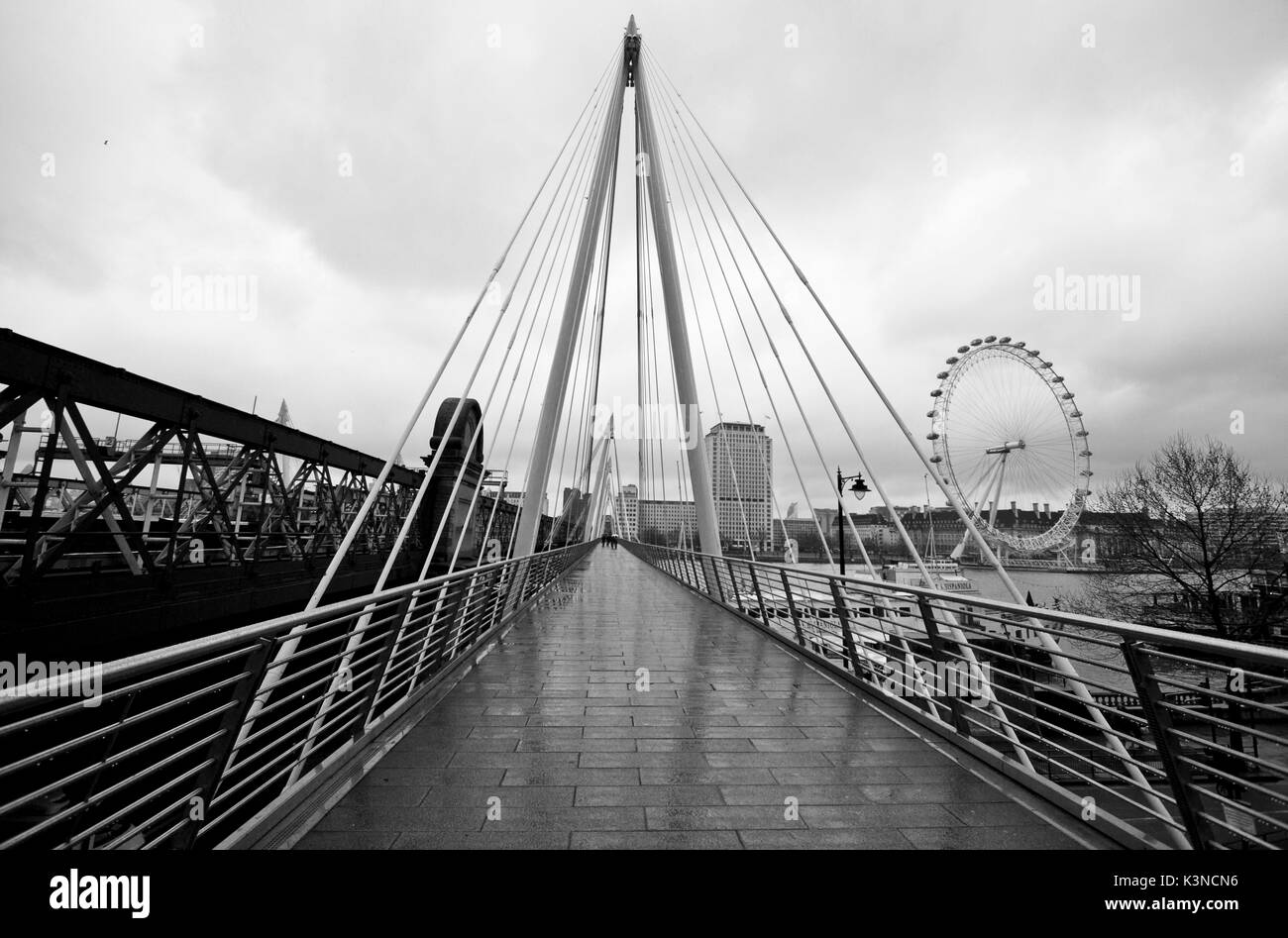 Le Golden Jubilee Bridge possède une architecture moderne qui rappelle les triangles et sur la gauche le London Eye, sur une journée avec la pluie. Londres, Angleterre, Europe. Banque D'Images