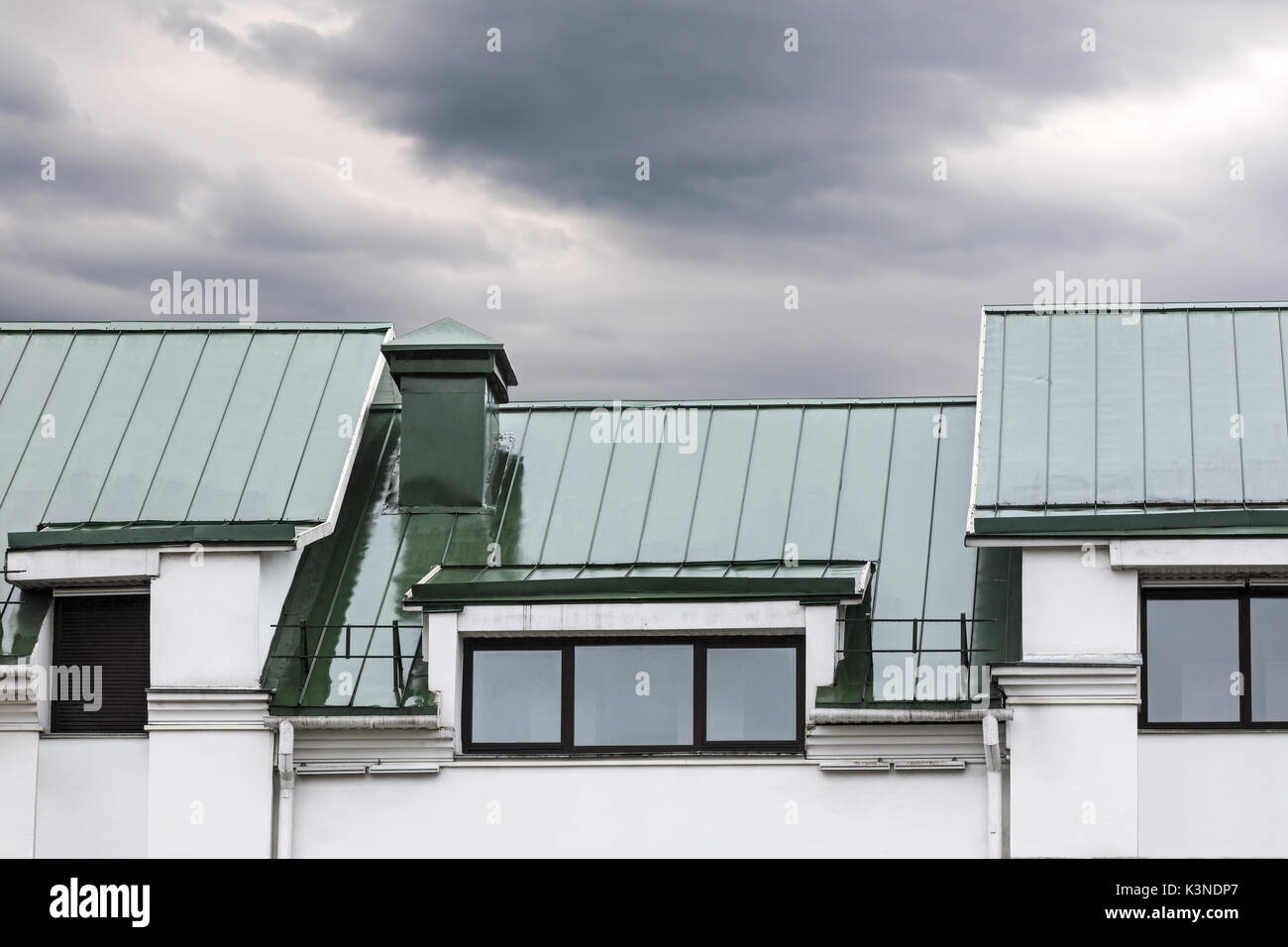 Toit en métal gris avec windows au cours de la pluie contre dark ciel nuageux Banque D'Images