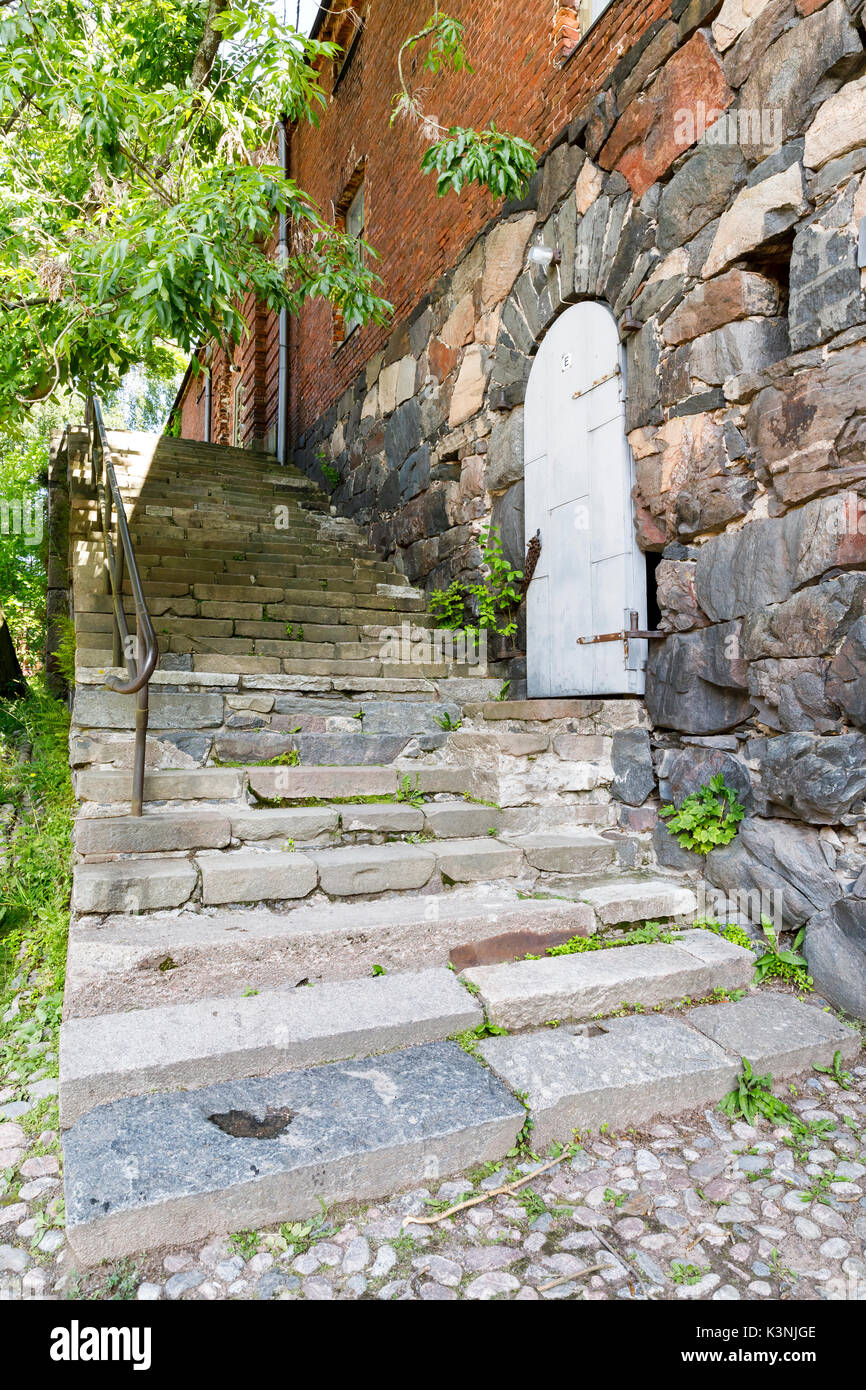 Escalier en pierre ancienne et une porte blanche dans le vieux bâtiment en pierre de la terre Banque D'Images