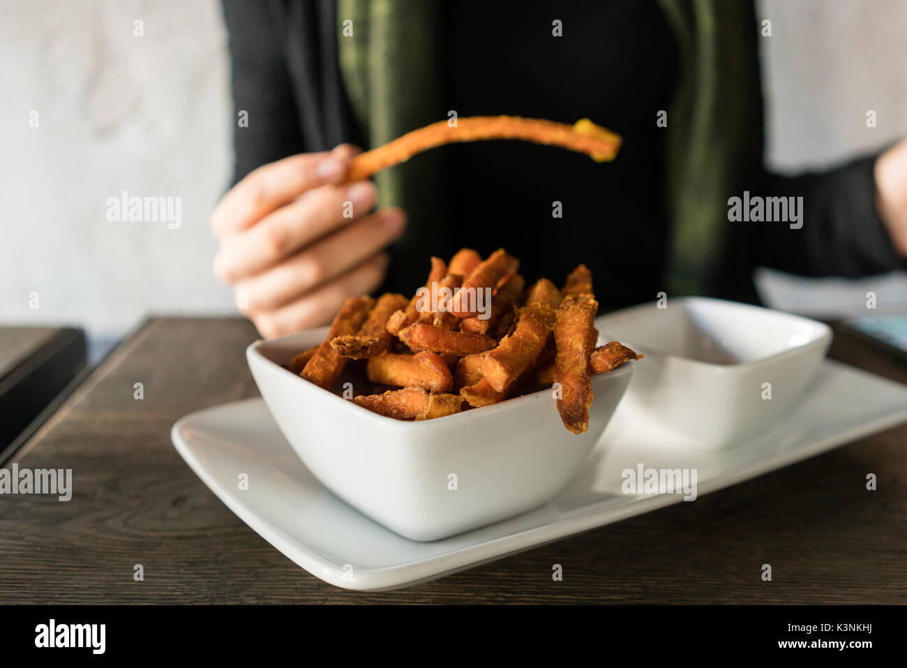 Woman eating frites de patates douces dans le Banque D'Images