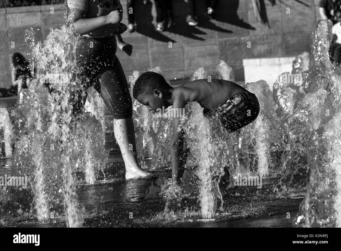 Manchester, Royaume-Uni - 15 août, 2017 : Enfants jouant au Piccadilly Gardens les fontaines d'eau dans le centre-ville de Manchester sur un jour d'été ensoleillé Banque D'Images